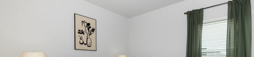 a bedroom with a bed and a window with green curtains