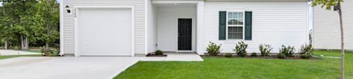 a white house with a lawn in front of it