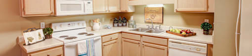 a kitchen with white appliances and wooden cabinets