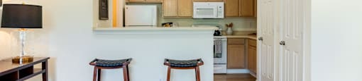 a kitchen and living room with two stools