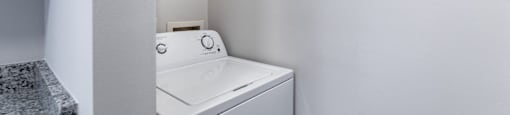 A white washing machine in a small laundry room.