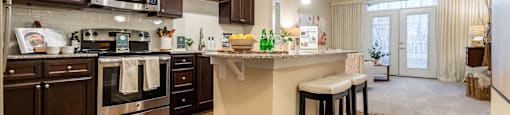 A kitchen with dark brown cabinets and a white island.