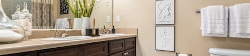 A bathroom with brown cabinets and a white toilet.