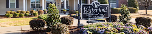 A sign for Waterford Residential Club in front of a building.