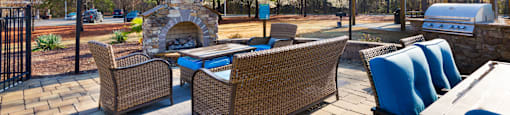 A patio with a table and chairs and a fireplace.
