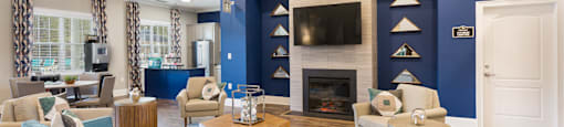 A living room with a blue couch and a fireplace.