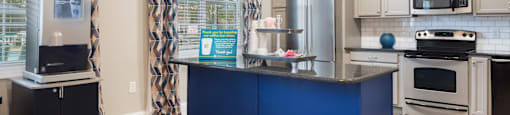 A kitchen with a blue island and white cabinets.