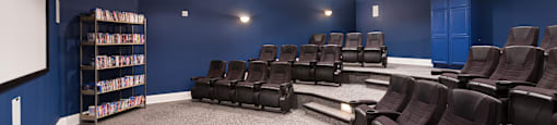A room with a carpeted floor and a row of black chairs.
