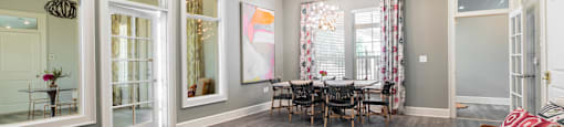 a living room with a dining room table and windows
