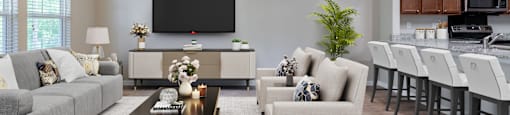 a living room with couches and chairs and a kitchen with a tv