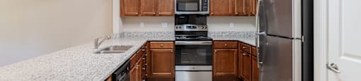 a kitchen with wood cabinets and granite counter tops and stainless steel appliances