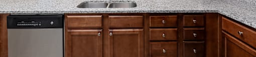 an empty kitchen with granite counter tops and wooden cabinets