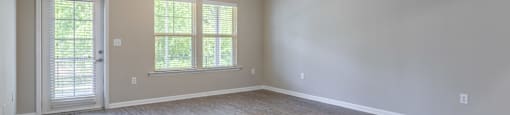 an empty living room with wood floors and a ceiling fan