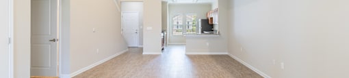 an empty living room with a hard wood floor and white walls