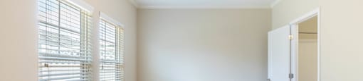 an empty room with a large window and a ceiling fan