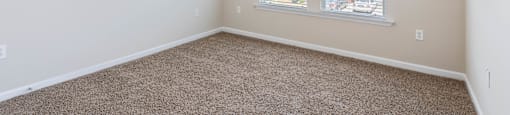 an empty bedroom with a ceiling fan and a window