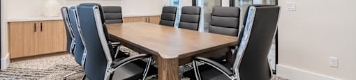A conference room with a large table and chairs.