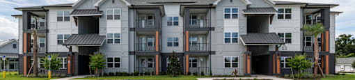 A large apartment building with a parking lot in front.