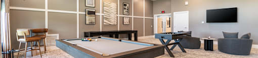 A room with a pool table and a television.