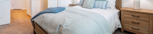 A bedroom with a bed, nightstand, and two lamps.