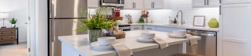 A modern kitchen with white cabinets and a central island.