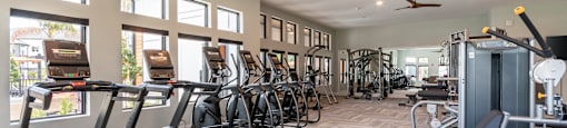 A gym with treadmills, exercise bikes, and other equipment at SW 38th Avenue Apartments in Ocala, FL.