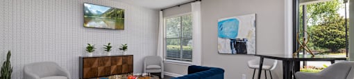 a living room with a blue couch and a table and chairs
