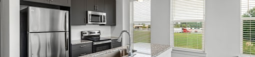 Altitude Raleigh kitchen with granite countertops and stainless steel appliances