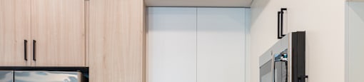 a kitchen with white cabinets and a stainless steel refrigerator