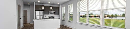 Altitude Raleigh kitchen with granite countertops and stainless steel appliances with views into the open living area