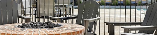 A patio with chairs and a fire pit.