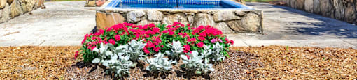 a fountain with flowers in front of a hotel sign