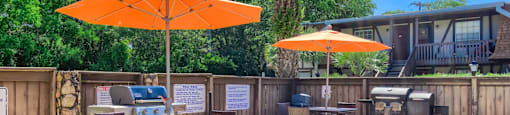 an outdoor patio with umbrellas and tables with chairs