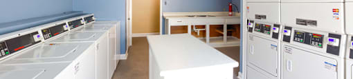 a laundry room with white appliances and blue walls