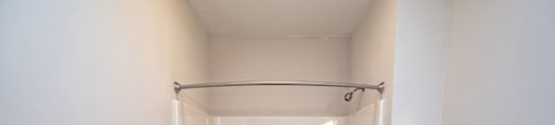 A white bathroom with a tub and shower combo and toilet at 2918 North Winstead Commons apartments in Greensboro, NC.