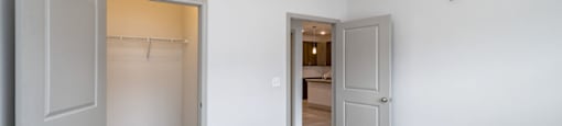A room with a grey carpet and two doors, one of which is open, at 2918 North Winstead Commons apartments in Greensboro, NC.