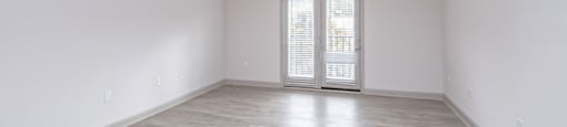A spacious room with a ceiling fan and sliding glass doors at 2918 North Winstead Commons apartments in Greensboro, NC.