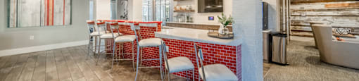 a kitchen with a bar and chairs in a house