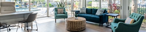 a living room with a couch chairs and a table with a chair and ottoman in