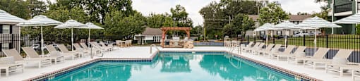 A large outdoor swimming pool with lounge chairs and umbrellas.