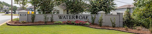 A sign that says "Watersoak" is in front of a grassy area.