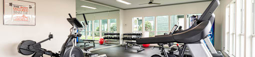 a gym with treadmills and other exercise equipment and windows