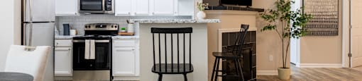 an open kitchen and living room with a dining room table and chairs