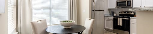 a kitchen and dining room with a table and chairs