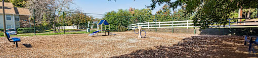 A playground with a swing set and a blue sign.