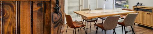 A room with a wooden door and a table with chairs.