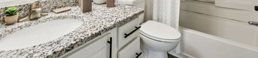 A white bathroom with a sink, toilet, and bathtub.