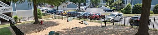 a playground in a fenced in area in a residential neighborhood