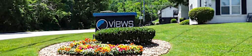 A sign that says "VIEWS" is in front of a house.