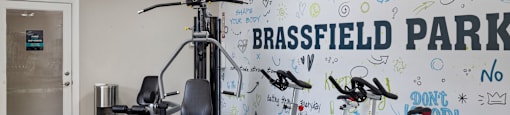 a gym with a white wall with writing on it and exercise equipment